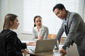 Asian business group discussing graph work at the office