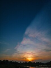 sunset and light in the sky like the aurora. silhouette of trees and rice fields in the afternoon