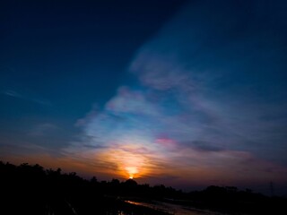 time lapse sunset. sunset and light in the sky like the aurora. silhouette of trees and rice fields...