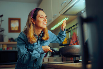 Woman Smelling the Aroma of Freshly Cooked Meal. Home cook enjoying new fresh breakfast dish 

