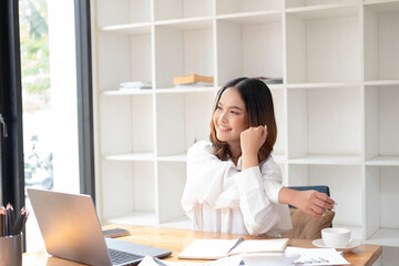 Attractive beautiful young asia female feel tired overworked negative impact health life stretching for break time relax stress relief in concept problem work remotely from home or burnout syndrome. © bunyiam