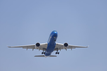 青空を背景に着陸態勢に入る飛行機