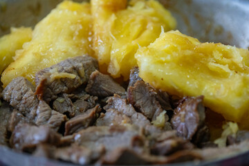 Traditional sun-dried meat with cooked cassava and bottled butter