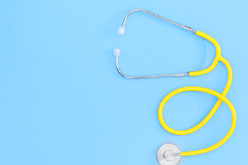 Yellow stethoscope against a blue background.