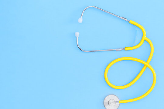 Yellow stethoscope against a blue background. - Powered by Adobe