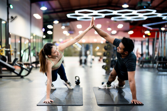 Athletic Sportsman and Sportswoman Doing Push Ups Together at Fitness Gym: Strength, Unity, and Motivation