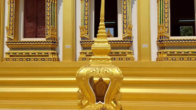 The Sema stands prominently next to the temple.  It is shaped like a pagoda with a spire and church windows.  gold color lined up