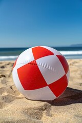 Close-up of a beach red white ball on the sand with the sea in the background
