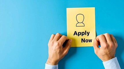 Hands Holding Apply Now Sign on Blue
