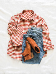 Suede chelsea boots, jeans, red plaid cotton shirt - comfortable women's clothing on a light background, top view