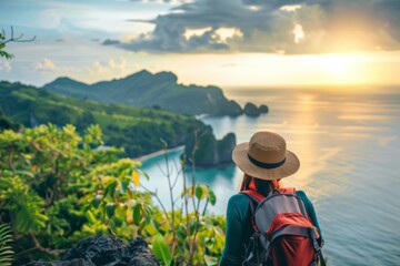 Obraz premium Woman with a hat looking out over the ocean at sunset, travel background