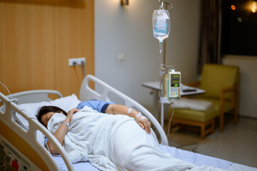 A patient lies sick in a hospital bed.