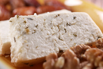 A detailed view of freshly served feta cheese complemented with walnuts on a plate