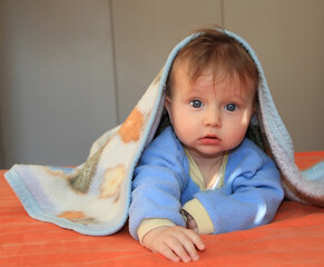 The baby with blue eyes covered with a blanket