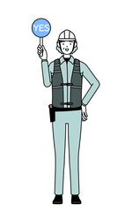 Senior female engineer in helmet and work wear holding a maru placard that shows the correct answer.