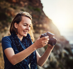 Travel, photography and happy woman with camera at a beach for sunset, shooting or scenic recording in nature. Photographer, lens and ocean for digital photoshoot or sunrise, vacation or trip