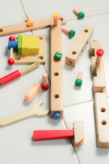 children hands playing with colorful wooden constructor puzzle bricks