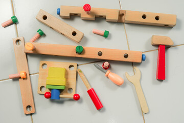 children hands playing with colorful wooden constructor puzzle bricks