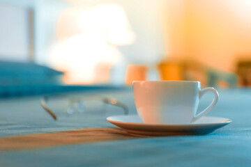 A Cup of Coffee and Glasses on a Bedside Table