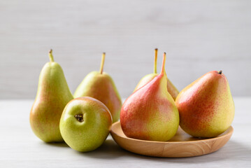 Fresh pear fruit on wooden plate with white table, Healthy fruit