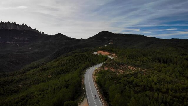 Mountain road with traffic pssing by at Montserrat mountain, Barcelona, Cataloia, Spain. High quality 4k drone view footage