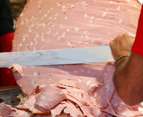 Giant mortadella sliced with a long knife during the town festival