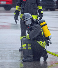 Firefighters with oxygen tanks and self-contained breathing apparatus with helmet with visors down...