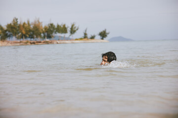 Sun-kissed Waves: A Smiling Asian Man Enjoying Active Water Sports and Leisure in a Tropical Beach...