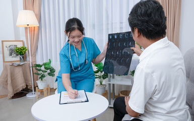 Doctor or nurse examines, explains x-ray results and takes treatment notes for an elderly man at the hospital.