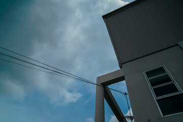 A wire is hanging from a building and the sky is cloudy