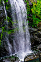 A waterfall with green moss growing on the rocks