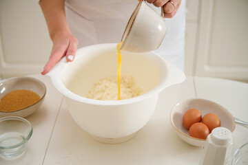 Adding eggs to the dough to make a pie. Process of cooking pecan pie in home kitchen for American Thanksgiving Day.