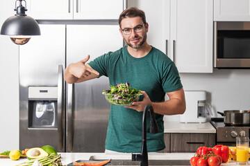 Portrait of attractive man preparing fresh natural weight loss meal at kitchen home indoors....