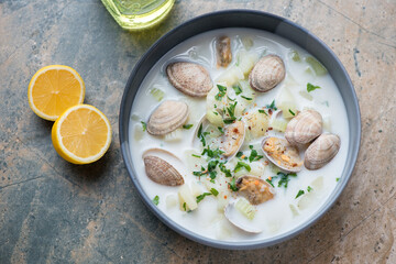 Bowl of new england chowder with vongole clams on a grey and beige granite background, horizontal shot, above view