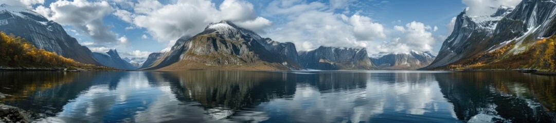 Fototapeta premium Panoramic landscape of a tranquil mountain lake surrounded by lush greenery and majestic mountains under a clear blue sky.