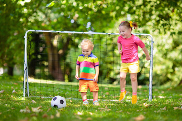 Kids play football. Child at soccer field.