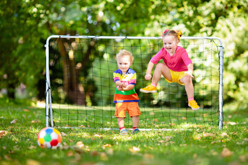 Kids play football. Child at soccer field.