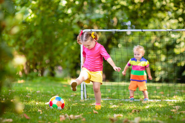 Kids play football. Child at soccer field.