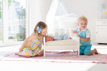 Kids play with newborn baby brother