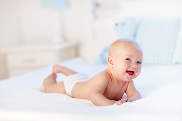 Baby boy on white bed