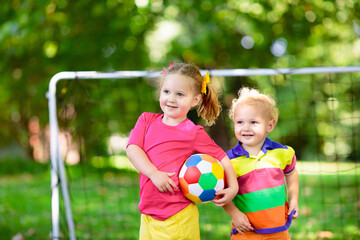 Kids play football. Child at soccer field.