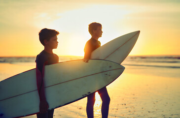 Sunset, surf and kid on beach with board for adventure on vacation, holiday or sport in water....