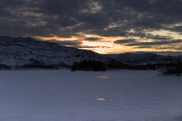 Fototapeta premium a view of a frozen lake with mountains in the background