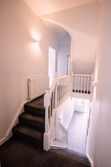 there is a small white staircase with a black carpet at the bottom