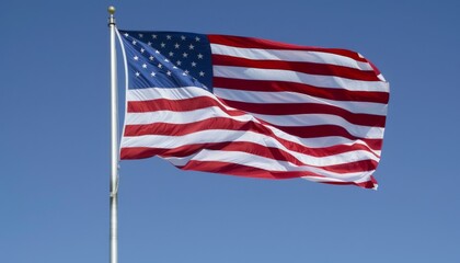 Obraz premium Flag of United States of America being waved in the breeze against a sky. USA flag