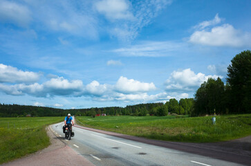 Cycling trip in Sweden, Cyclist on touring bicycle solo travel Nordic countryside in Värmland,...
