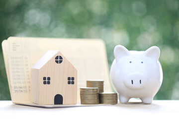 Finance, Model house with piggy bank and stack of coins money on natural green background,Business...