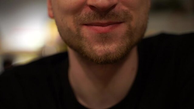 Young man wiping his lips with a napkin after eating, cropped shot without face, a person wipes their mouth with a yellow napkin after eating a mea