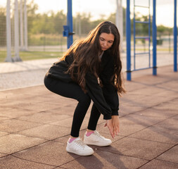 Woman in athletic wear Performing Squats on Outdoor Workout Equipment