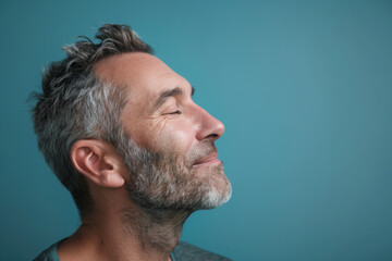 Obraz premium A close up of a man with beard and closed eyes looking to a side